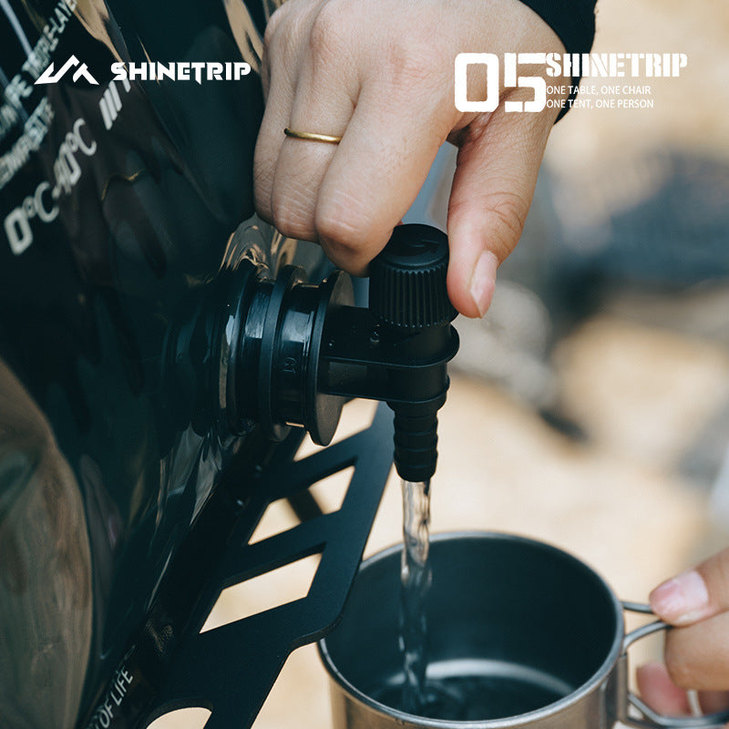 Person pouring liquid from a black spout into a metal cup, 8L foldable water container leakproof adjustable spout for easy pouring portable water bag