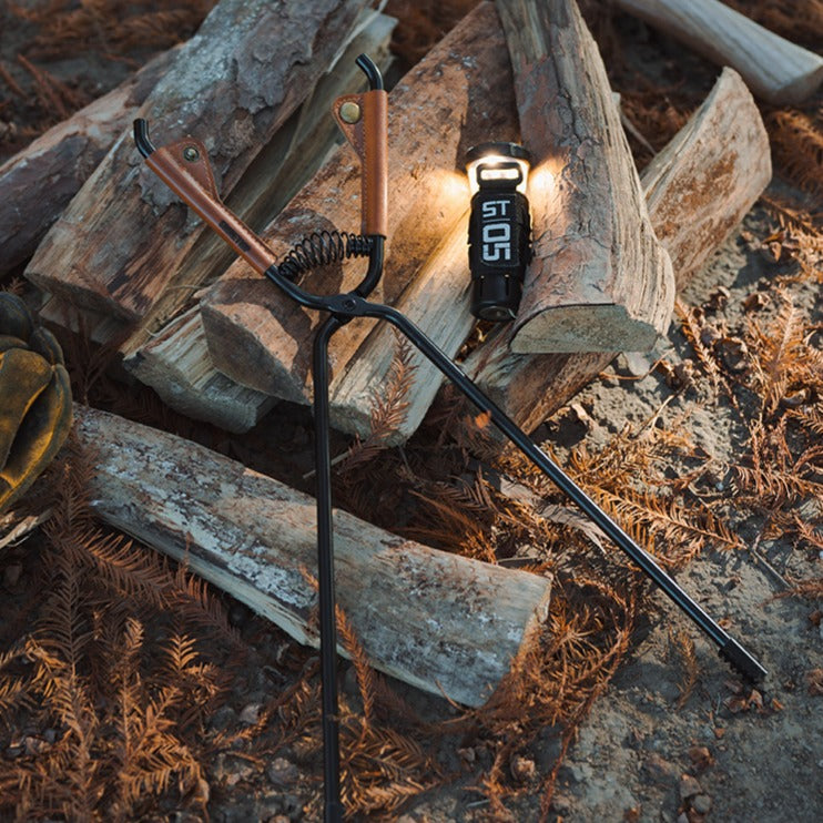camping fire tongs flat lay with wood lantern outdoor gear