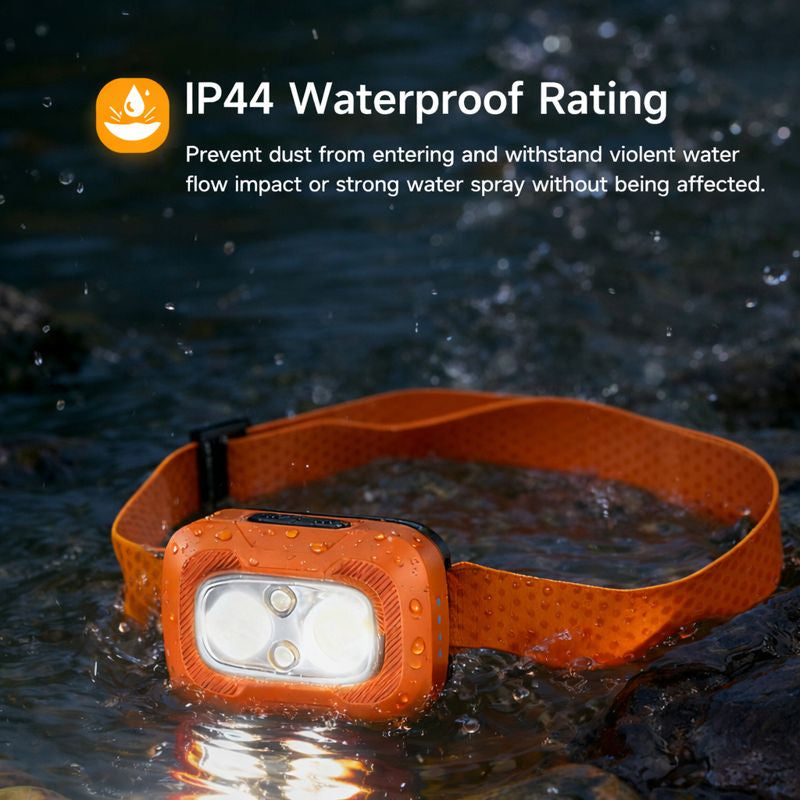 Orange waterproof headlamp with IP44 rating label being tested in water.